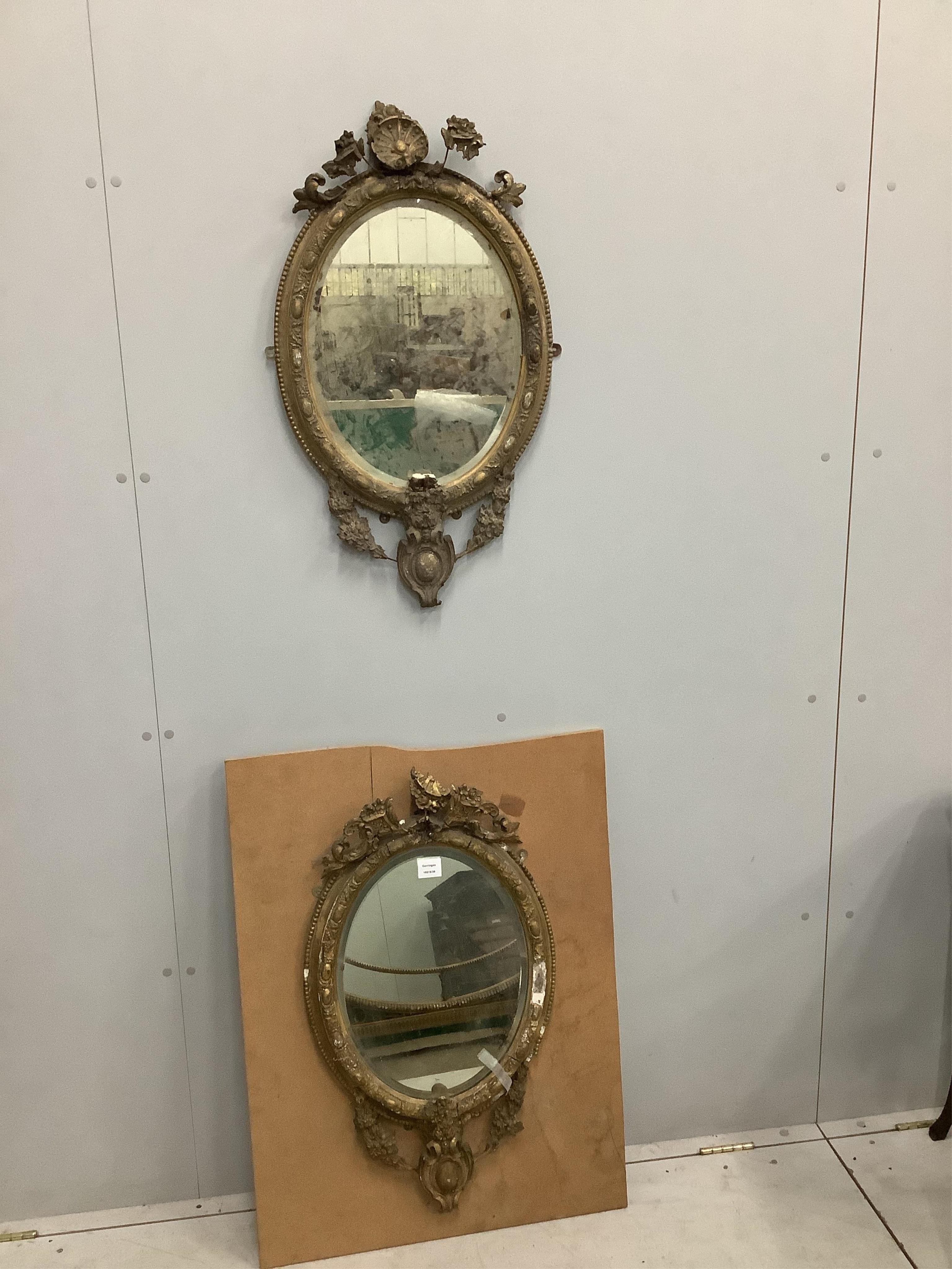 A pair of Victorian oval giltwood and gesso wall mirrors, in need of restoration, width 45cm, height 75cm. Condition - poor, in need of restoration